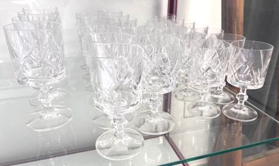 many wine glasses sitting on a glass shelf in a glass case