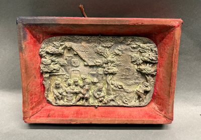 an image of a red box with a relief of a man and a woman in a garden
