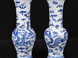 two blue and white vases with dragon designs on them on a black background