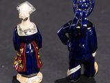 two figurines of a man and a woman standing next to each other