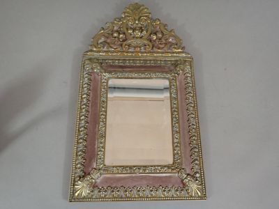 a small mirror with a gold frame on the wall