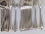 a lot of silverware on a white table