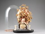 a glass dome with a figurine of a woman and two cats under it