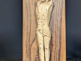 sculpture of a man on a cross on a wooden plaque