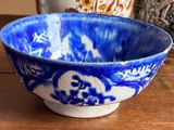 a blue and white bowl sitting on a wooden table