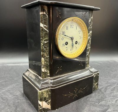 une horloge noire et or posée sur une table