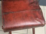 a brown leather chair sitting on a tile floor
