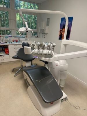 a dentist ' s chair in the corner of the room