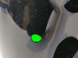 a close up of a helmet with a green light on it