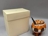 a small figurine of a tiger next to a box