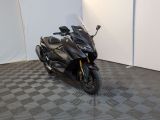 a black motorcycle parked in a room with a checkered floor