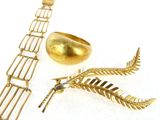 a gold bracelet and a gold ring on a white surface