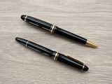 two pens sitting on top of a wooden table next to each other