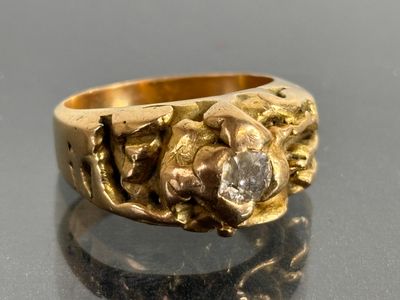 a gold ring with a diamond in it on a table