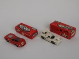 three toy cars sitting next to each other on a white surface
