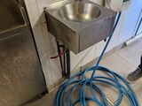 un tuyau bleu raccordé à un lavabo en métal dans une salle de bains