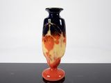 a black and orange vase sitting on a black table
