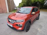 La voiture rouge est garée sur le bord de la route.