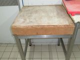 a small table with a cutting board on it in a kitchen
