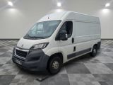 la camionnette blanche est garée dans une grande pièce au sol en damier