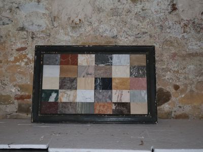 une photo d'un tableau posé sur un rebord devant un mur de briques