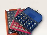 several different types of coins are in a case on a white surface