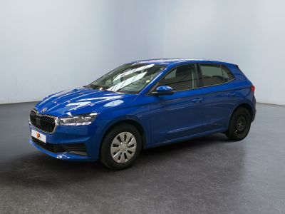 une voiture bleue garée dans une pièce aux murs blancs