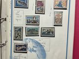 an open book with stamps on it and a world map on the page
