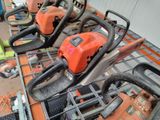 several chainsaws are lined up on a table in a warehouse