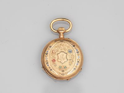 a close up of a gold pocket watch on a white surface