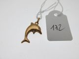 un petit pendentif en forme de dauphin en or, suspendu à une étiquette