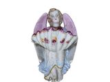 une figurine représentant un ange assis sur une surface blanche