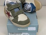 des chaussures de petit garçon dans une boîte posée sur une surface blanche
