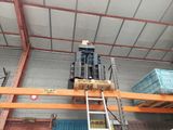 a fork lift in a warehouse with pallets on the floor