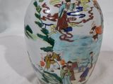un vase avec un tableau posé sur une table