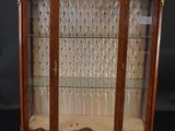 an antique display cabinet with glass doors and gold trimmings