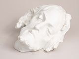 a white sculpture of a man ' s face on a table