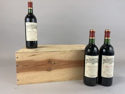 trois bouteilles de vin sont posées sur une caisse en bois
