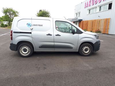 une camionnette grise garée sur un parking devant un immeuble