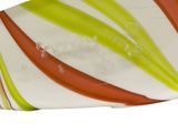 brightly colored glass plate on white background with red, yellow, and green stripes