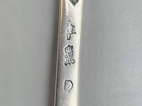 a silver spoon with writing on it sitting on a table
