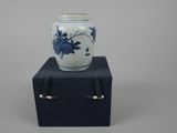 a blue and white vase sitting on top of a black box