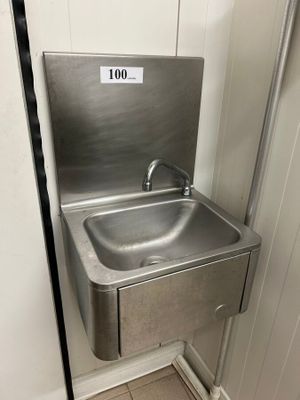 un évier en acier inoxydable dans le coin d'une salle de bains