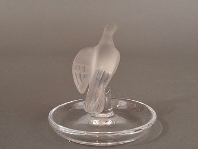 a glass bird that is sitting on a glass plate