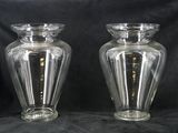 une paire de vases en verre transparent posés sur un fond noir
