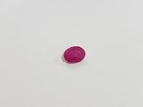 a pink oval shaped stone on a white surface