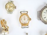 many different types of watches displayed on a white surface
