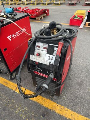 une soudeuse électrique posée sur un parking, à côté d'autres équipements