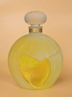 une image représentant un flacon de parfum jaune contenant une rondelle de citron