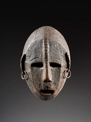 une image d'un masque en bois sur fond noir